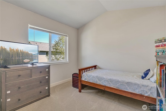 bedroom featuring lofted ceiling, baseboards, and carpet flooring