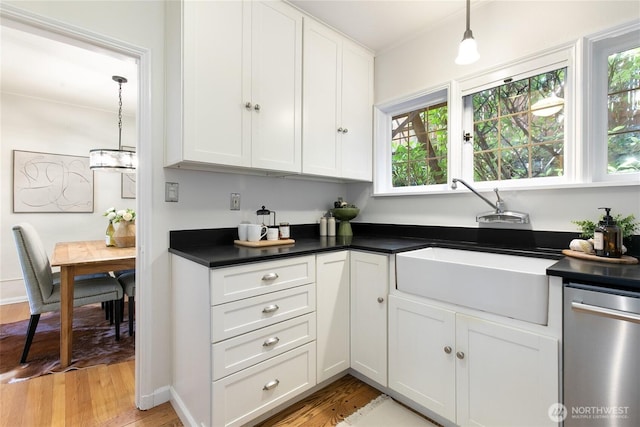 kitchen featuring dark countertops, white cabinets, light wood-style flooring, and dishwasher