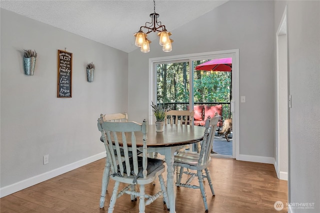 791 NE Pinecrest Dr, Bremerton, WA 98311 - dining room with a chandelier, baseboards, lofted ceiling, wood finished floors, and a textured ceiling