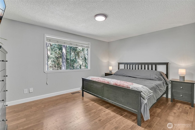 791 NE Pinecrest Dr, Bremerton, WA 98311 - bedroom with baseboards, wood finished floors, and a textured ceiling