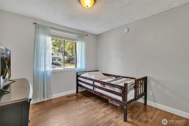791 NE Pinecrest Dr, Bremerton, WA 98311 - bedroom with a textured ceiling, baseboards, and wood finished floors