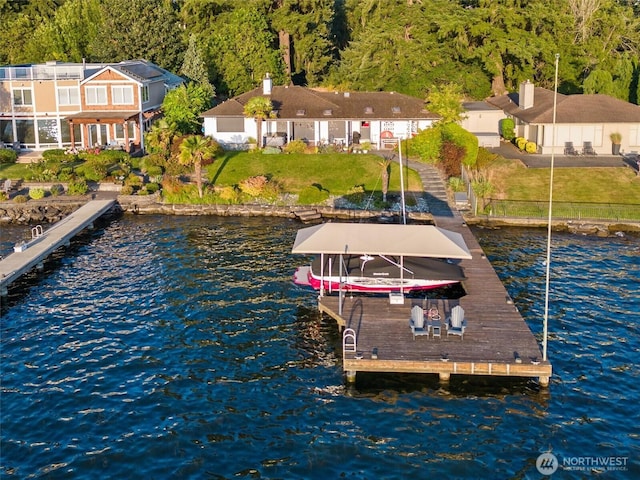 dock area with a view of trees, boat lift, and a water view