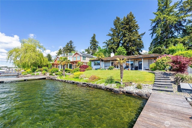 dock area with a yard and a water view