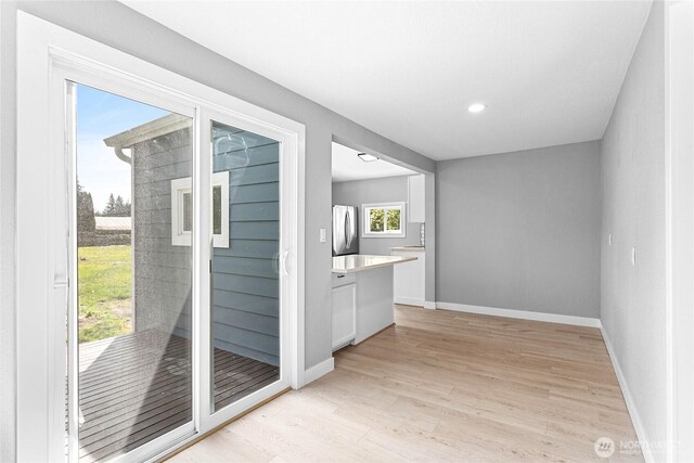 doorway to outside featuring recessed lighting, baseboards, and light wood-style floors