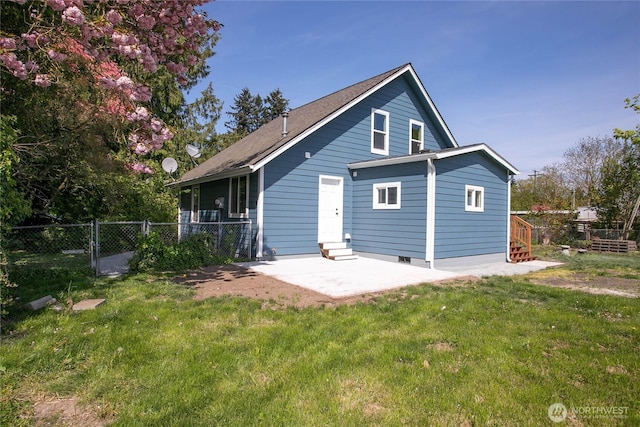 back of property with a lawn, a patio, and fence