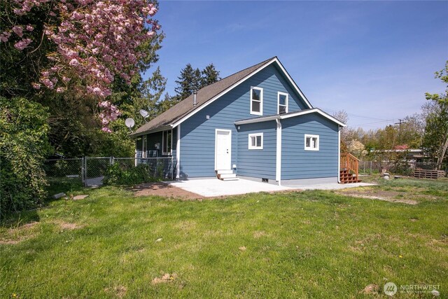 rear view of property featuring a patio area, fence, and a yard