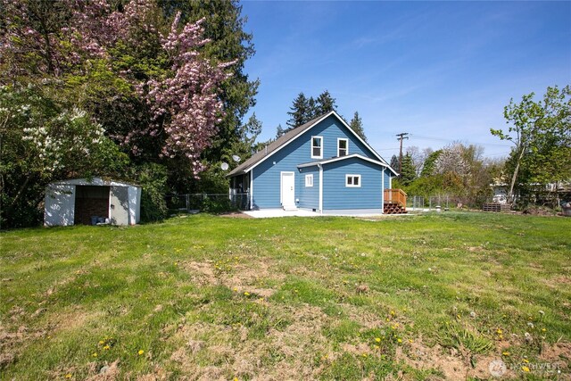 exterior space with a lawn, fence, an outbuilding, and a shed
