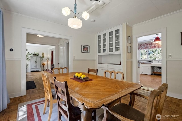 dining space featuring crown molding and an inviting chandelier
