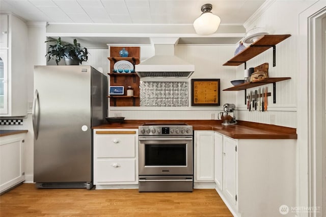 kitchen with open shelves, butcher block counters, light wood-style floors, range hood, and stainless steel appliances