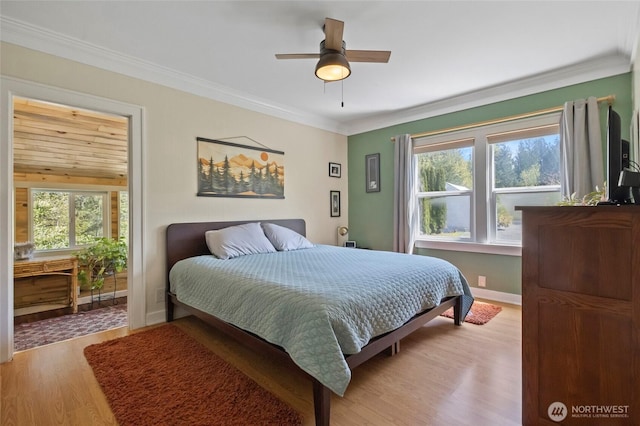 bedroom with ornamental molding, light wood finished floors, and multiple windows