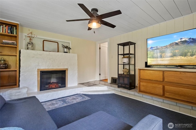 living room with ceiling fan, a fireplace, and carpet flooring