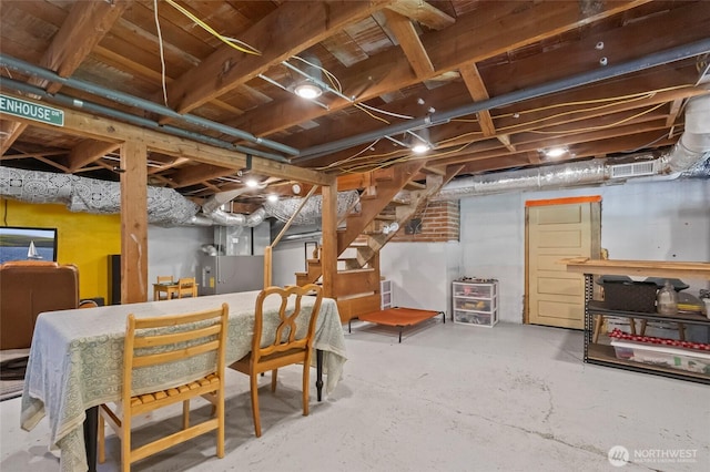 unfinished basement with heating unit, stairs, and visible vents