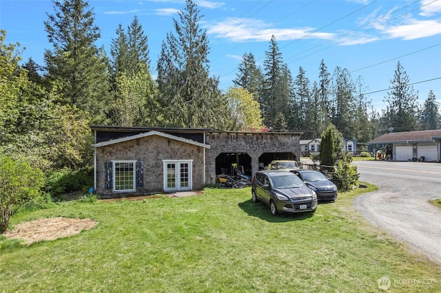 view of front of house featuring dirt driveway, french doors, and a front yard