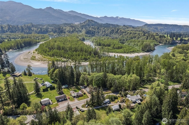 aerial view with a wooded view and a water and mountain view