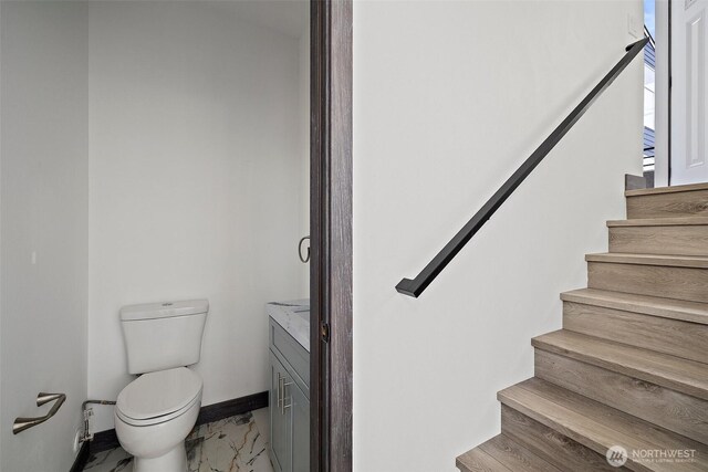 stairway featuring baseboards and marble finish floor