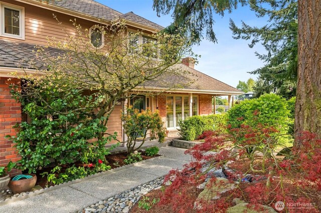 exterior space with a chimney and brick siding