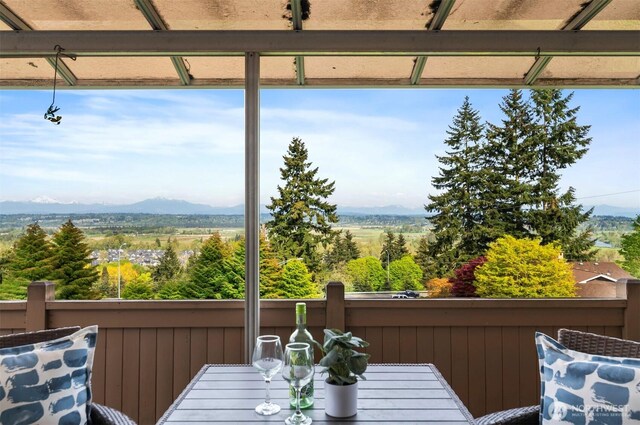 exterior space with a mountain view, outdoor dining space, and a balcony