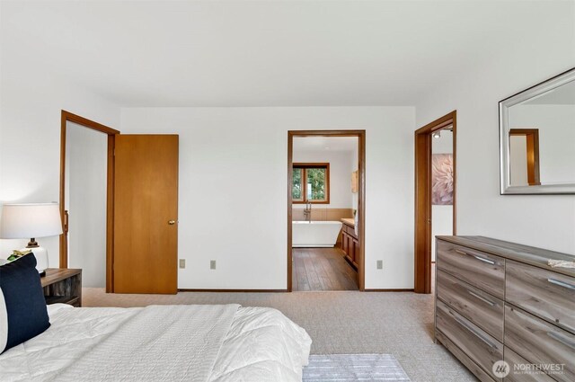 bedroom featuring baseboards, carpet flooring, and ensuite bathroom