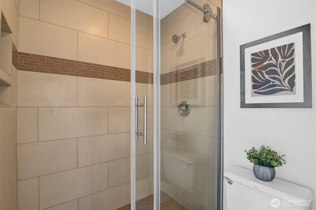 full bathroom with toilet and a shower stall