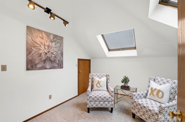 living area with baseboards, carpet, and lofted ceiling with skylight