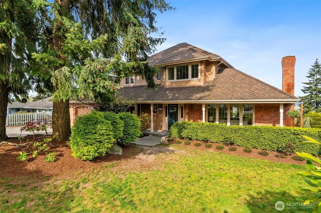 view of front of property featuring fence, a front yard, a chimney, a shingled roof, and an attached garage