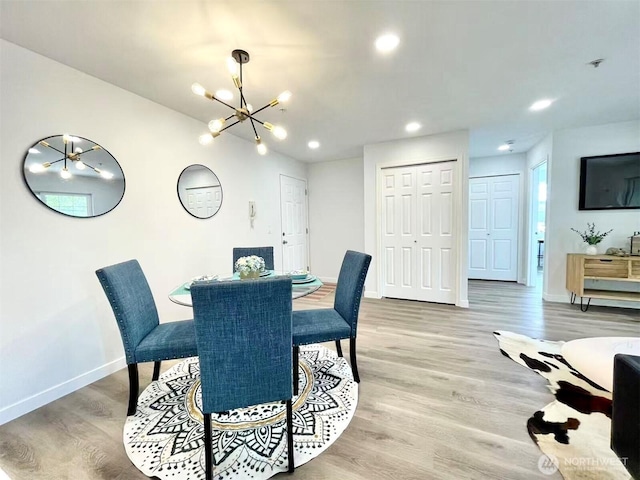 dining area with a chandelier, baseboards, light wood finished floors, and recessed lighting
