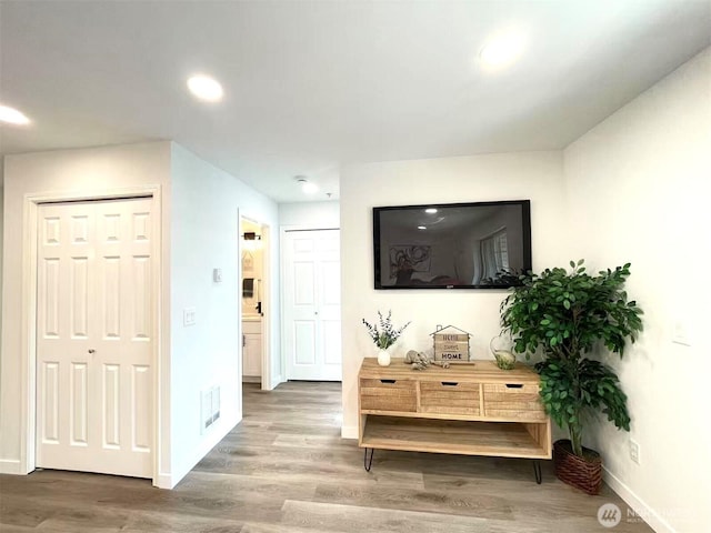 living area with wood finished floors, baseboards, and recessed lighting