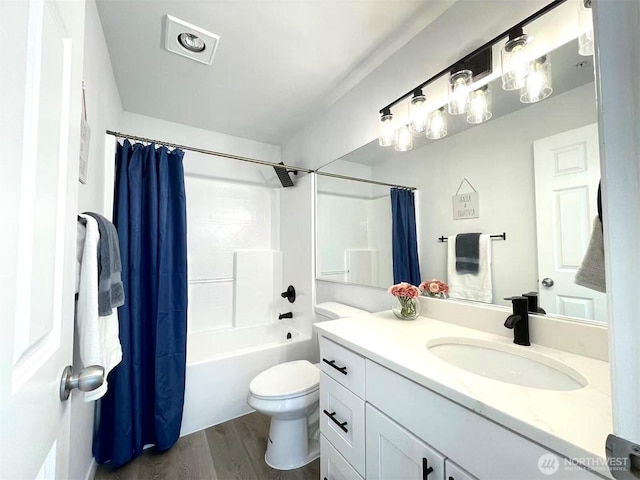full bath featuring wood finished floors, toilet, vanity, and shower / bathtub combination with curtain