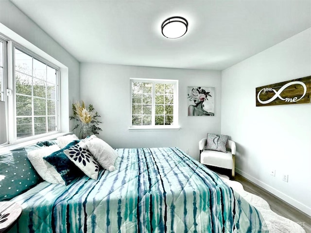 bedroom featuring wood finished floors and baseboards