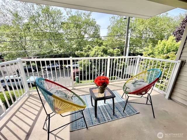 balcony featuring view of scattered trees