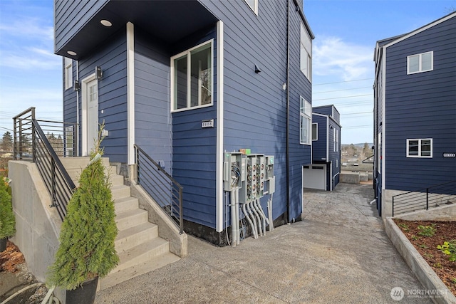view of side of property with fence and concrete driveway