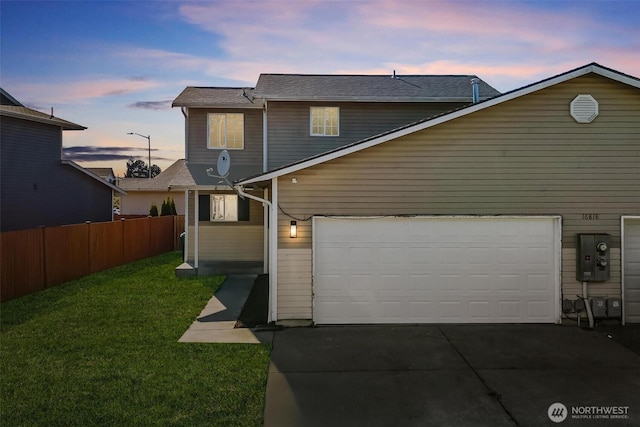 rear view of property with fence, a yard, and driveway