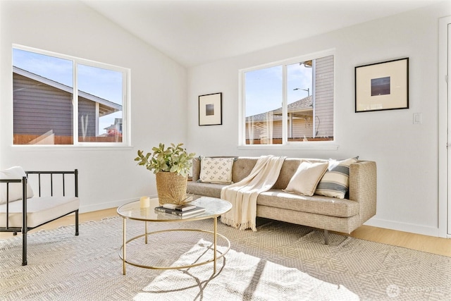 living room with baseboards, a wealth of natural light, lofted ceiling, and wood finished floors