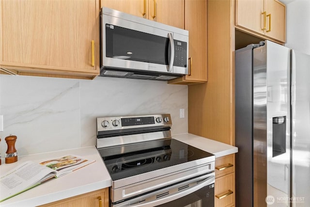 kitchen featuring light countertops, stainless steel appliances, and light brown cabinets