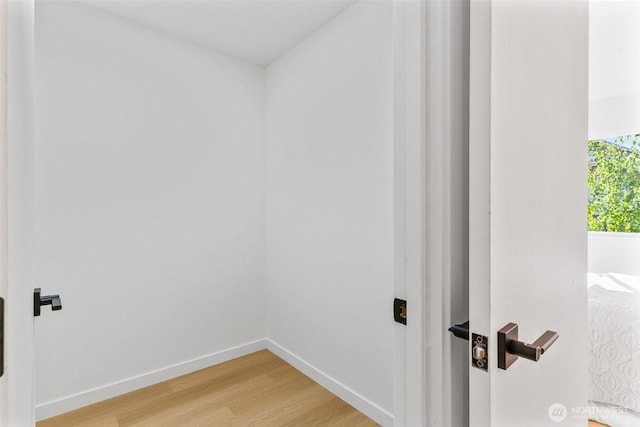 interior space featuring baseboards and light wood finished floors