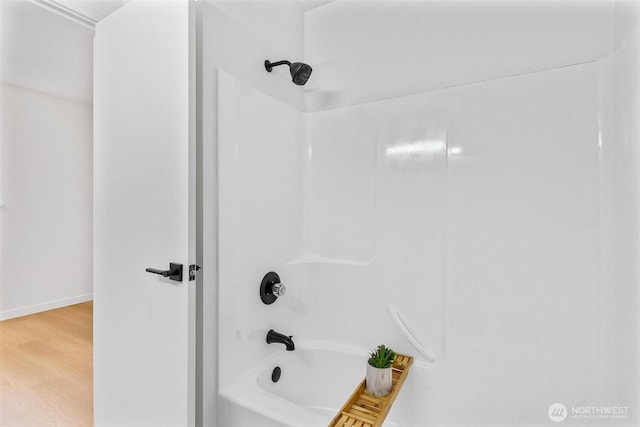 full bathroom featuring shower / bath combination and wood finished floors