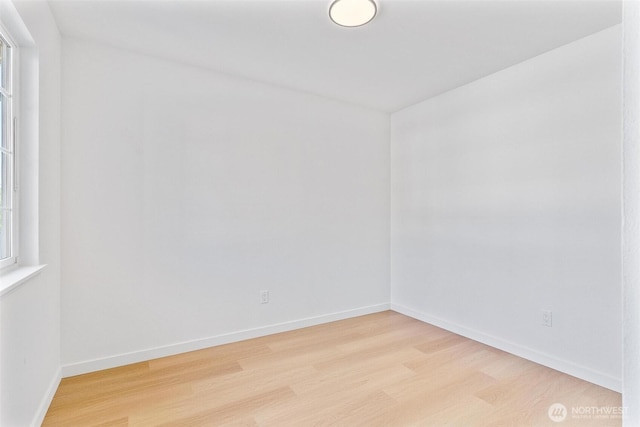 unfurnished room featuring baseboards and light wood-type flooring