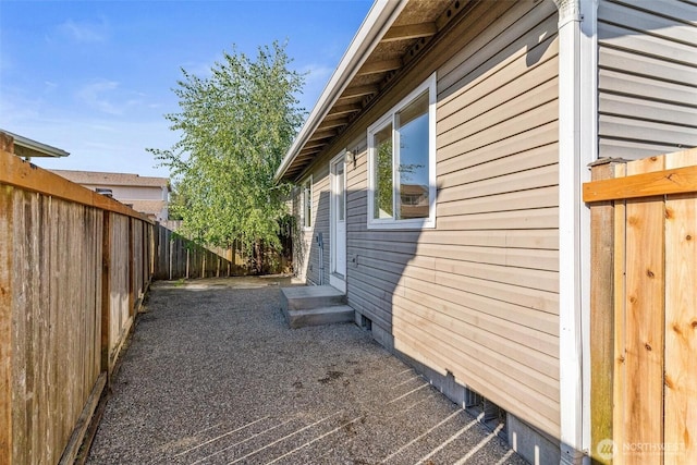 view of side of home with entry steps and fence
