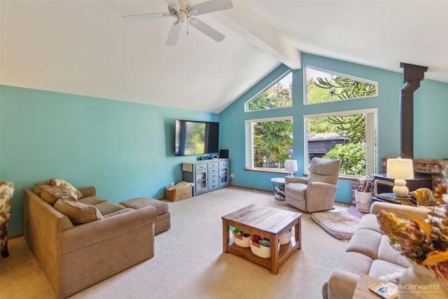 living room featuring a ceiling fan, a wood stove, beam ceiling, carpet floors, and high vaulted ceiling