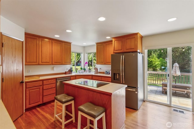 kitchen with a kitchen island, recessed lighting, appliances with stainless steel finishes, and light wood-style flooring