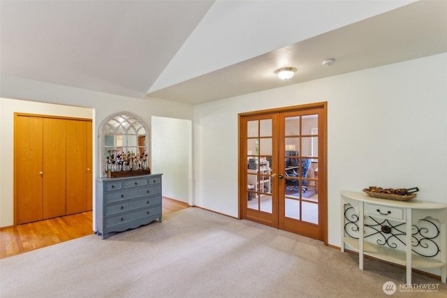bedroom with french doors, carpet, and lofted ceiling