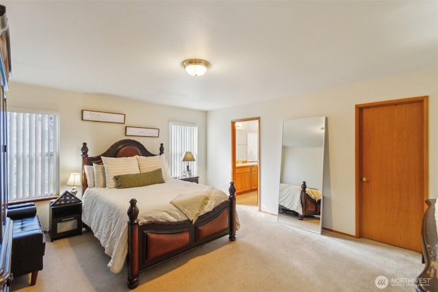 bedroom featuring light colored carpet and ensuite bathroom