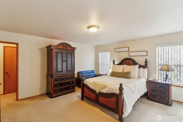 bedroom with light colored carpet, baseboards, and multiple windows