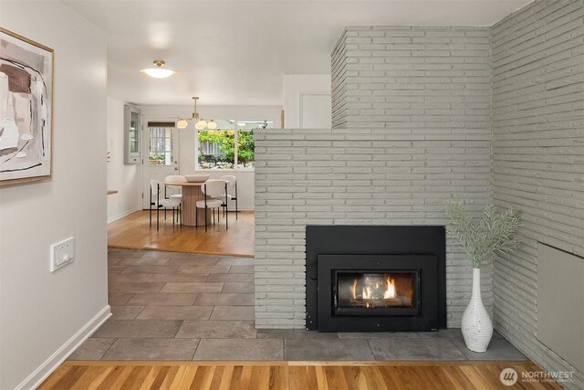 interior details with baseboards, wood finished floors, and a fireplace
