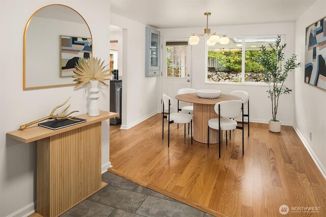 dining room with baseboards, wood finished floors, and a notable chandelier