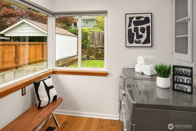 entryway with baseboards, independent washer and dryer, and wood finished floors