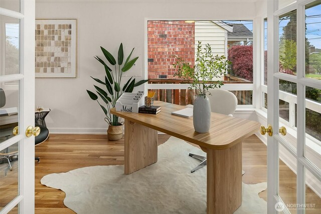 office area with baseboards, french doors, and wood finished floors