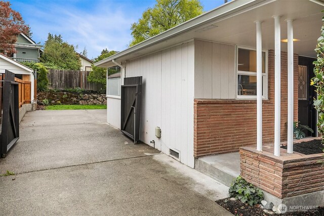view of property exterior featuring a patio area and fence
