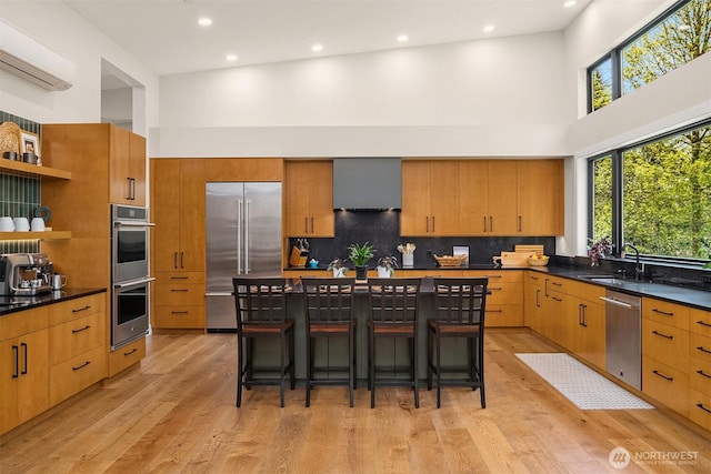 kitchen featuring stainless steel appliances, open shelves, a sink, and a towering ceiling