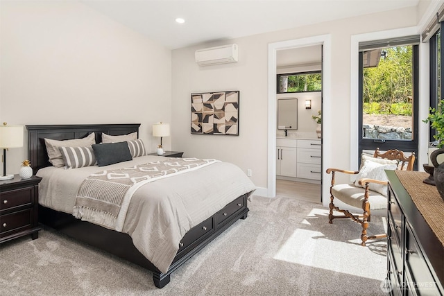 bedroom with light carpet, ensuite bath, an AC wall unit, recessed lighting, and baseboards